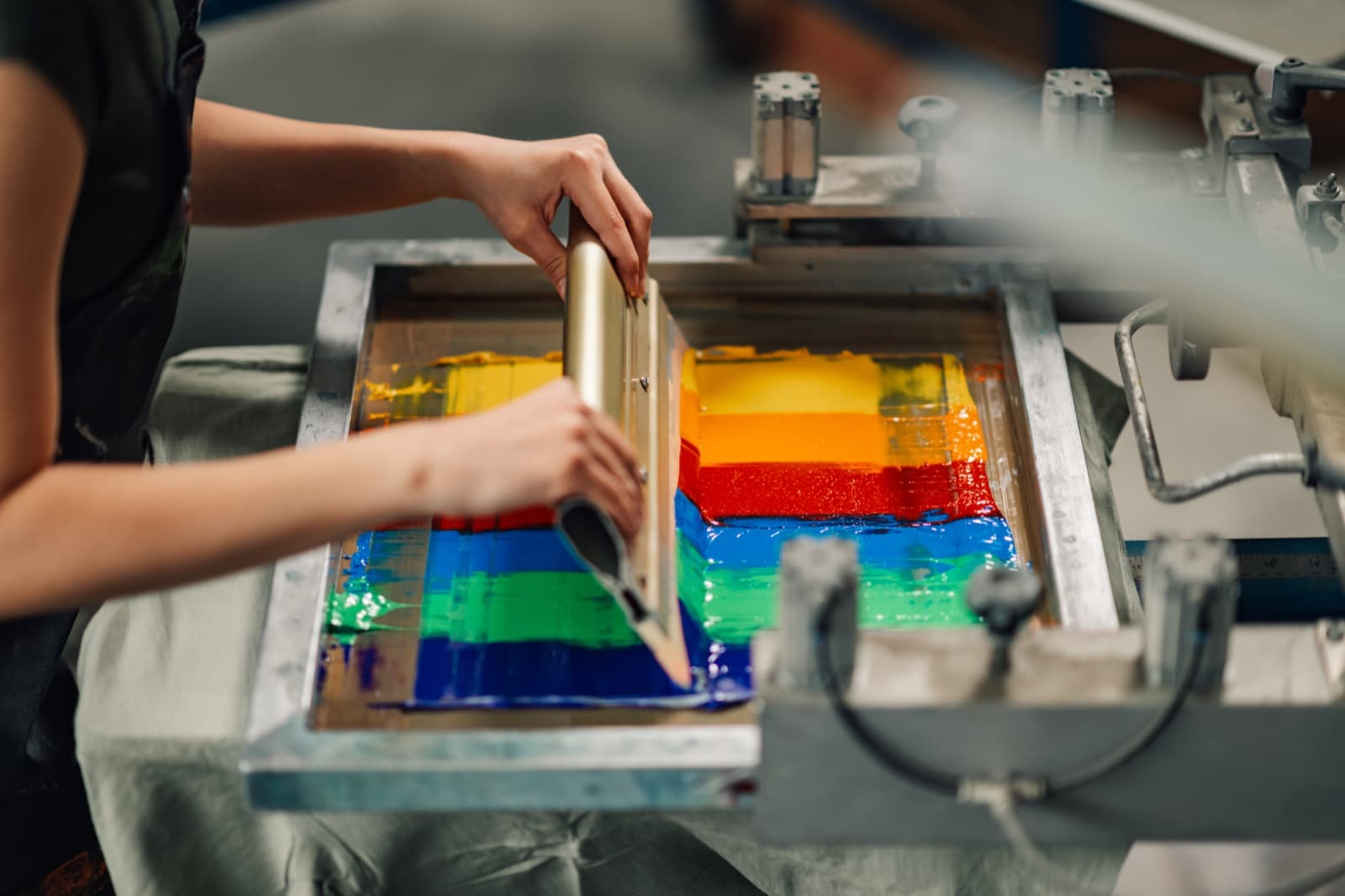 Technician pressing ink through a screen